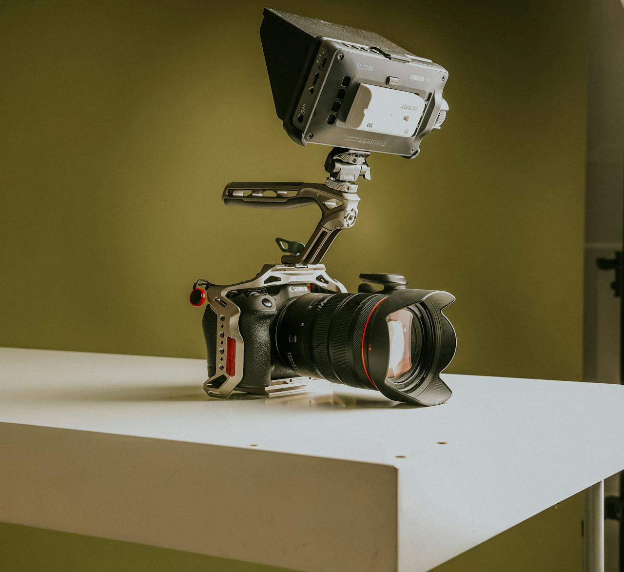 High-quality professional video camera setup with attached monitor on a minimalist platform.